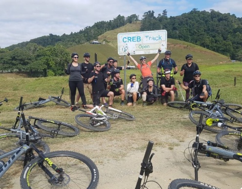 A group of cyclists standing in front of the Creb Track Sign